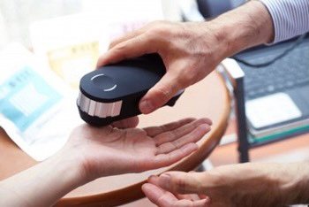 OligoScan practitioner placing device on patient palm at MyThrivelytics Rockville MD